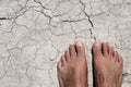 Bare feet of a man on a cracked dry soil Royalty Free Stock Photo