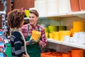 Customer buying plastic pots at the advice of a helpful worker in flower shop