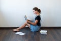 High angle view of beautiful girl using laptop and smiling at camera while sitting on carpet and studying at home Royalty Free Stock Photo