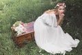 high angle view of beautiful young bride sitting on vintage chest and looking Royalty Free Stock Photo