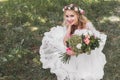 high angle view of beautiful young bride in wedding dress holding bouquet of flowers and smiling at camera Royalty Free Stock Photo