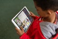 High angle view of biracial boy learning over video call in online class on digital tablet at home Royalty Free Stock Photo