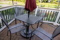 High angle view of a black patio table with chairs and a red umbrella on an outdoor deck Royalty Free Stock Photo