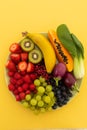 High angle view of bowl of banana, berries, grapes and baby aubergines