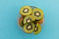 High angle view of bowl of freshly cut kiwi on blue background