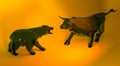 High-angle view of the bull and bear statuettes on the orange background Royalty Free Stock Photo