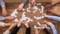 High Angle View Of Businesspeople Solving Jigsaw Puzzle