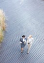 High angle view of businesswomen discussing while walking on floorboard Royalty Free Stock Photo