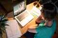 High angle view of caucasian businesswoman discussing with colleague over laptop at night in office Royalty Free Stock Photo