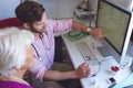 Male doctor showing medical reports on computer in a clinic room Royalty Free Stock Photo