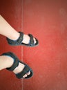 High angle view of child& x27;s feet with sandals on red floor Royalty Free Stock Photo