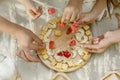 High angle view of children hands enjoying cheese dessert decorated with watermelon