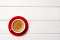 High angle view of coffee in red cup with saucer on white wooden background, close up Royalty Free Stock Photo