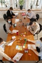 High angle view colleagues working together in face masks during quarantine in a office using modern devices and gadgets Royalty Free Stock Photo