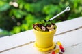 High angle view a cookie crumbs in a yellow pot decorated with worm jelly, chocolate gravel and peppermint with toy shovel on