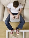 High angle view of cool young man typing on laptop