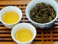 High angle view of cups of green oolong tea and tea leaves on a wooden tray Royalty Free Stock Photo