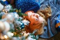 High angle view of cute woman lying on floor near christmas tree with gifts. Royalty Free Stock Photo
