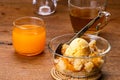 High angle view of delicious homemade peach cobbler with a scoop of vanilla ice cream and metal spoon in transparent glass bowl on