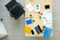 High angle view of the desk in the office. Laptop computer, tablet, mobile phone, credit card, coffee, stationary, document, graph