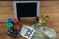 High angle view of digital tablet and whisky with currency on table during poker game