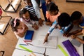 High angle view of diverse male teacher using laptop teaching children in elementary school class Royalty Free Stock Photo