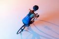 High angle view of female cyclist riding a bicycle isolated against neon background Royalty Free Stock Photo