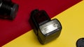 camera accessories, flash, lens, and lens cap on the red and yellow background at a high angle position Royalty Free Stock Photo