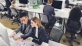 High angle view of focused businessman and businesswoman using desktop computer and working with papers