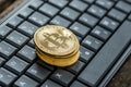 High angle view of four golden bitcoins on a keyboard