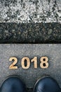 Feet and number 2018, as the new year, on asphalt