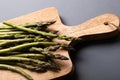 High angle view of fresh green asparagus on wooden cutting board over gray background Royalty Free Stock Photo