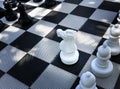 High angle view of giant checkered plastic mat with Black and White big Chess figures for playing on the ground board, chess Royalty Free Stock Photo