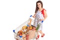 High angle view of girl smiling at camera while pushing a shopping cart full with groceries isolated on white background Royalty Free Stock Photo