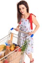 High angle view of girl smiling at camera while pushing a shopping cart full with groceries isolated on white background Royalty Free Stock Photo