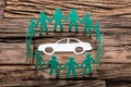 Green Paper Team Surrounding Car On Wooden Table