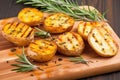 high angle view of grilled potatotes and rosemary on a board