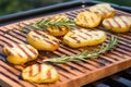 high angle view of grilled potatotes and rosemary on a board