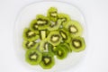 High angle view on group sliced fresh green shiny kiwi fruits on white plate