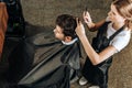 High angle view of hairstylist cutting hair to handsome young man