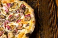High angle view of half of tasty pizza with ham, mushrooms, onion and pickles