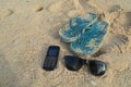 High angle view of handphone with flip-flops and sunglasses on sand at beach Royalty Free Stock Photo