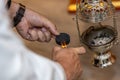 High-angle view of hands lighting a lump of coal for the botafumeiro Royalty Free Stock Photo