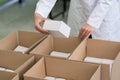 High-angle view of hands of worker putting packed products in ca Royalty Free Stock Photo