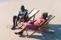 High angle view of happy african american senior couple sitting on deckchairs and talking at beach Royalty Free Stock Photo