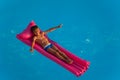 Happy boy relaxing on inflatable mattress in pool