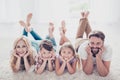 High angle view of happy family of four relatives, lying with cr