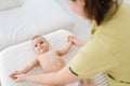 High-angle view of happy infant baby boy lying in bed playing with mom at home. Caring young mother doing gymnastic Royalty Free Stock Photo