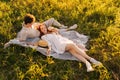 High-angle view of happy young woman lying of handsome man during romantic picnic in nature, on background of warm Royalty Free Stock Photo