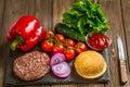 High angle view of ingredients for classic beef burger on stone board with knife. Selective focus. Royalty Free Stock Photo